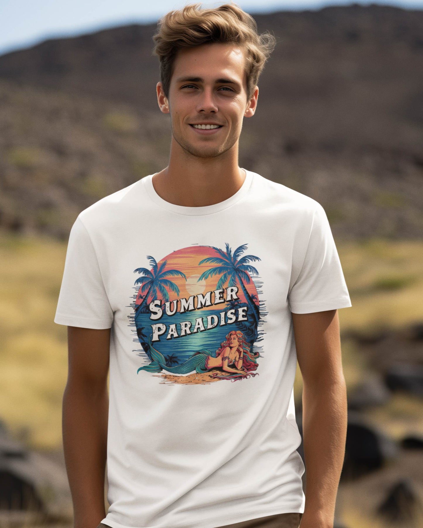 a-smiling-man-standing-against-some-mountains-wearing-a-white-t-shirt-printed-with-a-mermaid-resting-on-the-beach-whit-a-sunset-sun-in-background