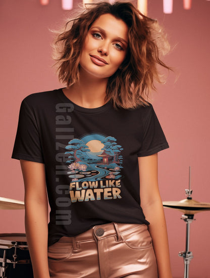 A-young-woman-with-wavy-brown-hair-and-soft-makeup-poses-confidently-in-a-black-t-shirt-with-a-Flow-Like-Water-design-features-a-tranquil-landscape-with-a-pagoda-flowing-water-and-lotus-flowers-under-a-full-moon