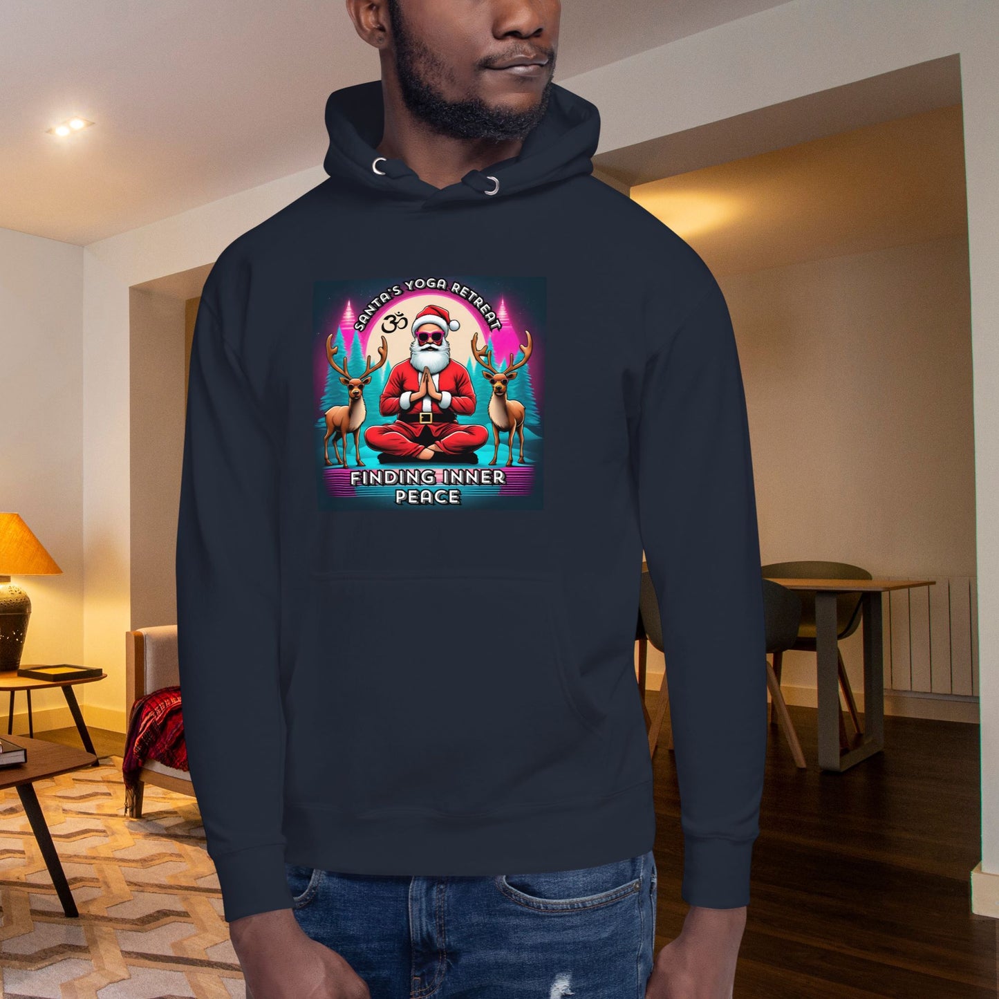 Chic-black-hoodie-with-a-festive-graphic-design-modeled-by-a-man-in-jeans-sitting-in-a-simple-setting