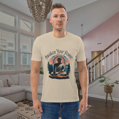Man wearing a t-shirt with a Buddha graphic and 'Awaken Your Power' text in a living room.