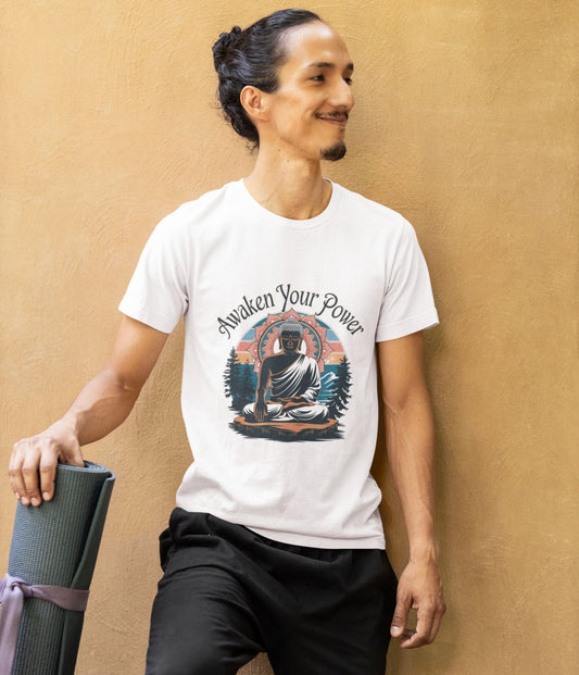 Smiling man in white zen graphic shirt with a peaceful figure design, holding yoga mat, leaning against a wall