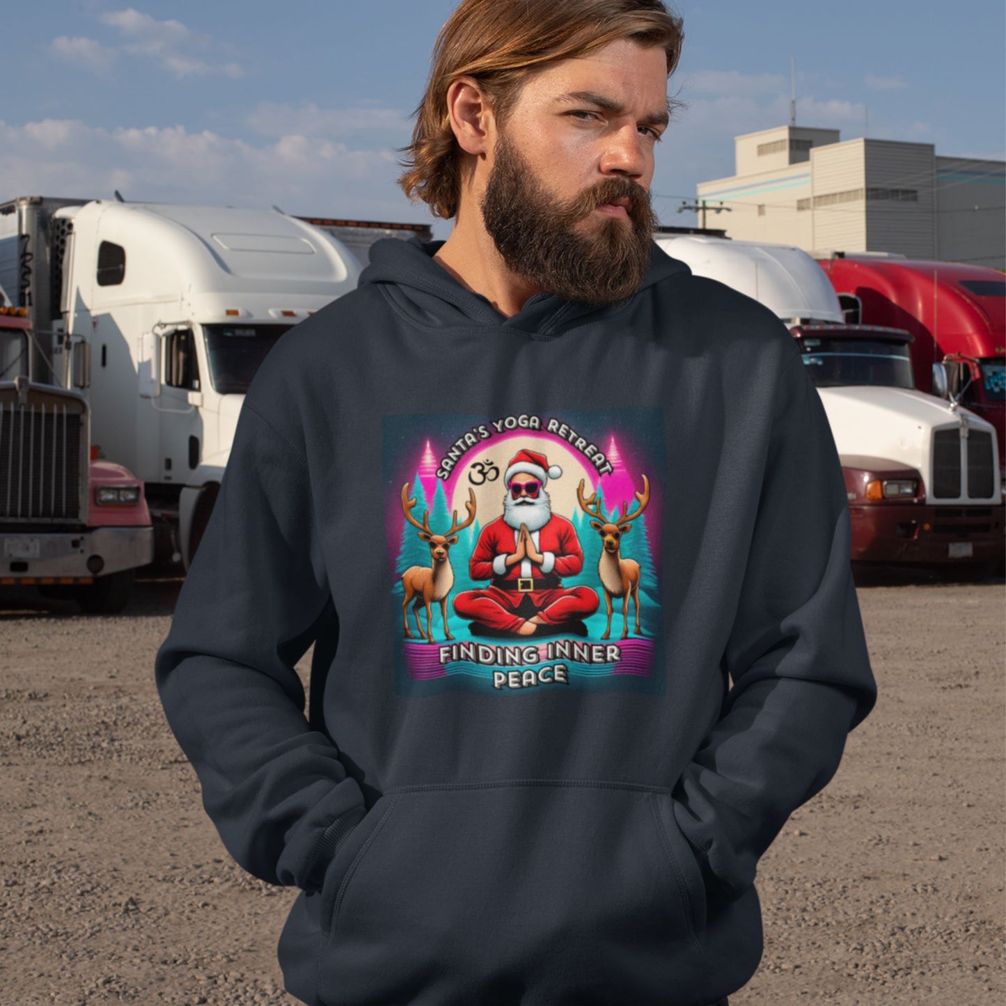 Parking-lot-shot-of-a-bearded-male-model-in-a-dark-blue-hoodie-with-a-quirky-Christmas-themed-graphic-surrounded-by-trucks