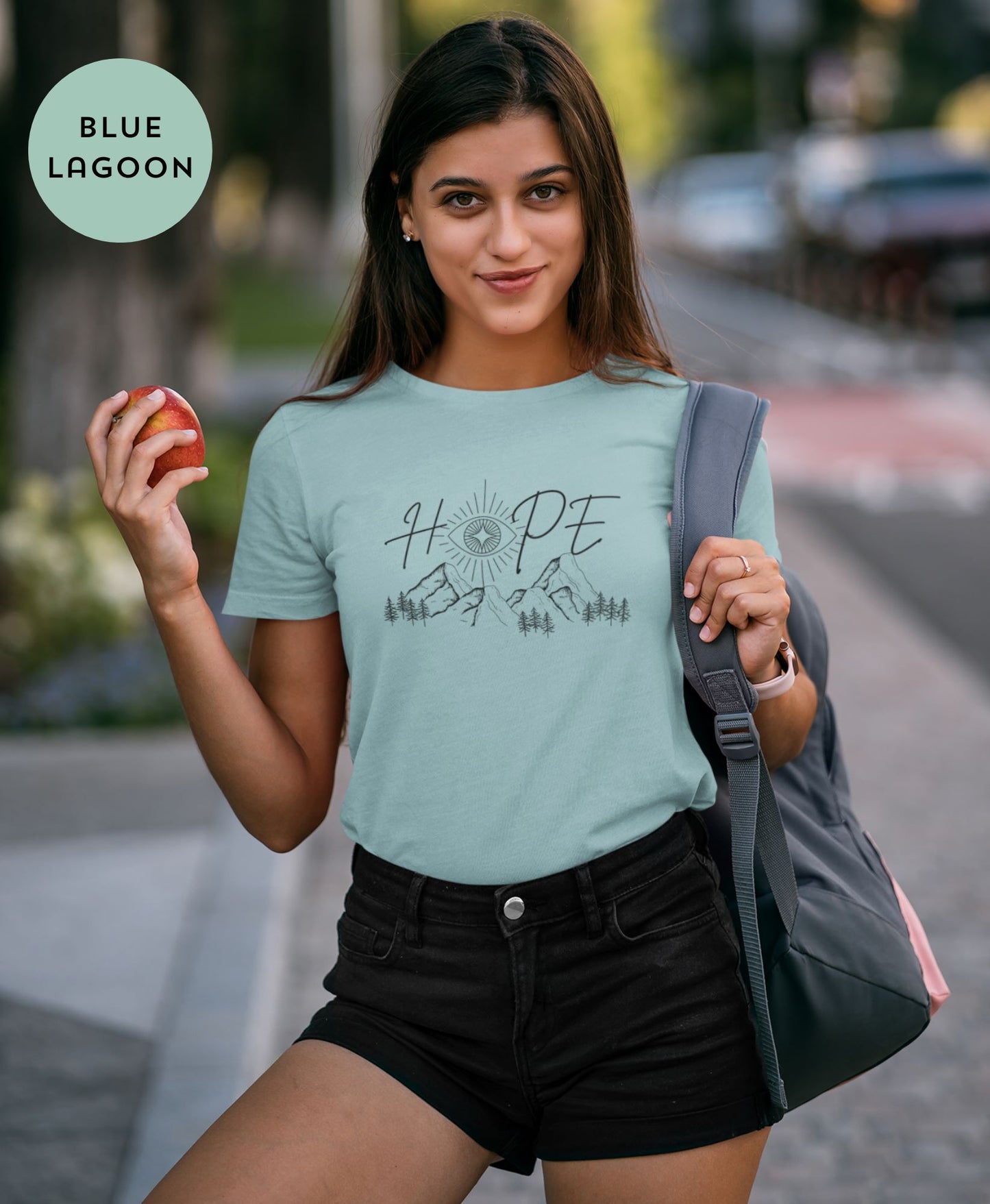 Smiling-young-woman-in-Blue-Lagoon-t-shirt-spreading-positive-vibes-on-a-sunny-street