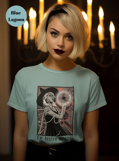 Woman-in-a-light-blue-t-shirt-with-a-witch-inspired-design-posed-in-front-of-candlelight-capturing-a-mystical-vibe