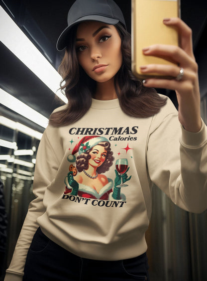 Woman-taking-a-selfie-in-a-beige-Christmas-sweatshirt-with-festive-text-Christmas-Calories-Dont-Count-paired-with-a-black-baseball-cap