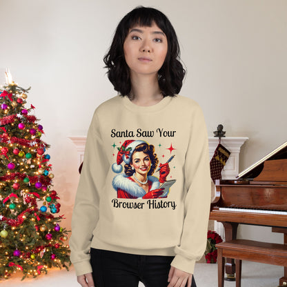 Woman-wearing-a-cream-colored-sweatshirt-with-text-Santa-Saw-Your-Browser-History-featuring-a-retro-style-Santa-Claus-Girl-illustration-standing-next-to-a-Christmas-tree