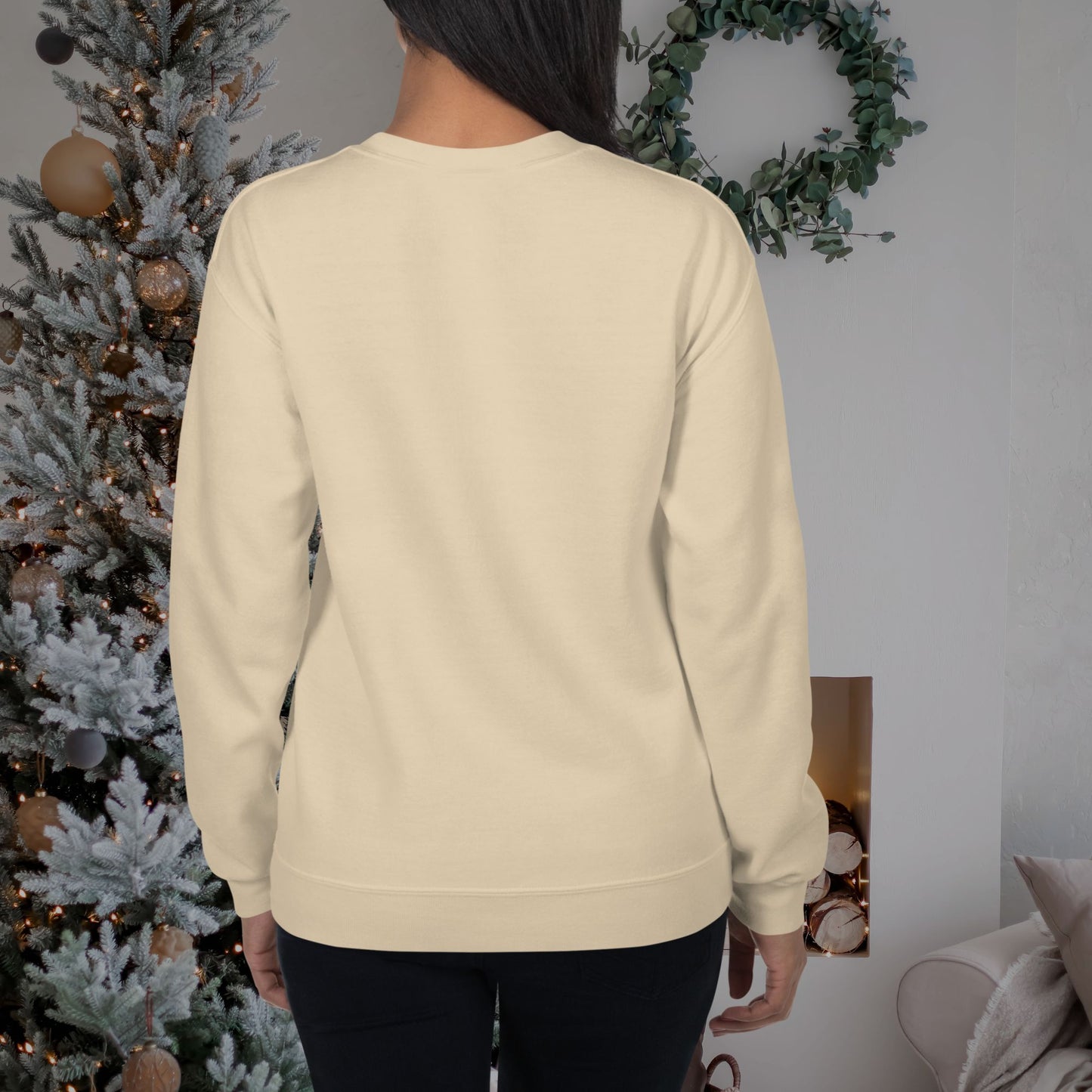 Woman-wearing-a-holiday-sweatshirt-near-a-decorated-tree