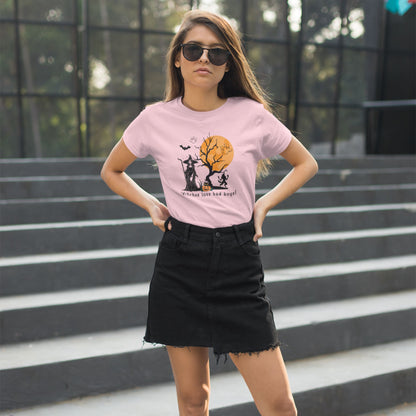 Young-female-model-posing-in-urban-setting-wearing-a-witch-graphic-pink-T-shirt-for-Halloween-and-a-short-black-dress