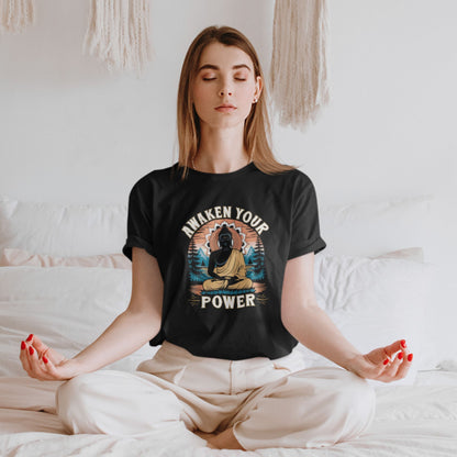Person wearing a black t-shirt with a Buddha graphic and 'Awaken Your Power' text, sitting in a meditative pose.