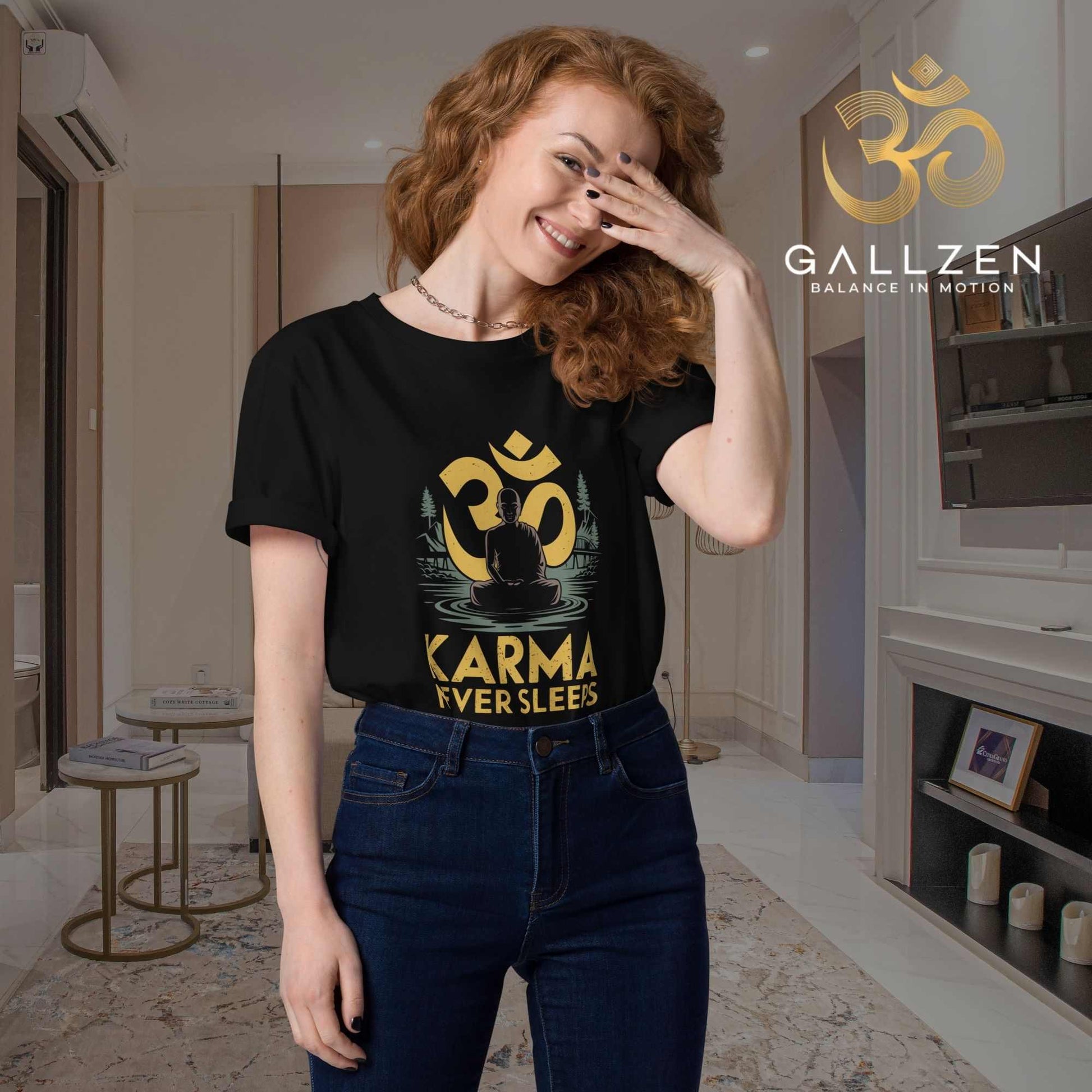 Red-haired woman with a hand covering her face wearing a black mindfulness t-shirt indoors in a modern living room