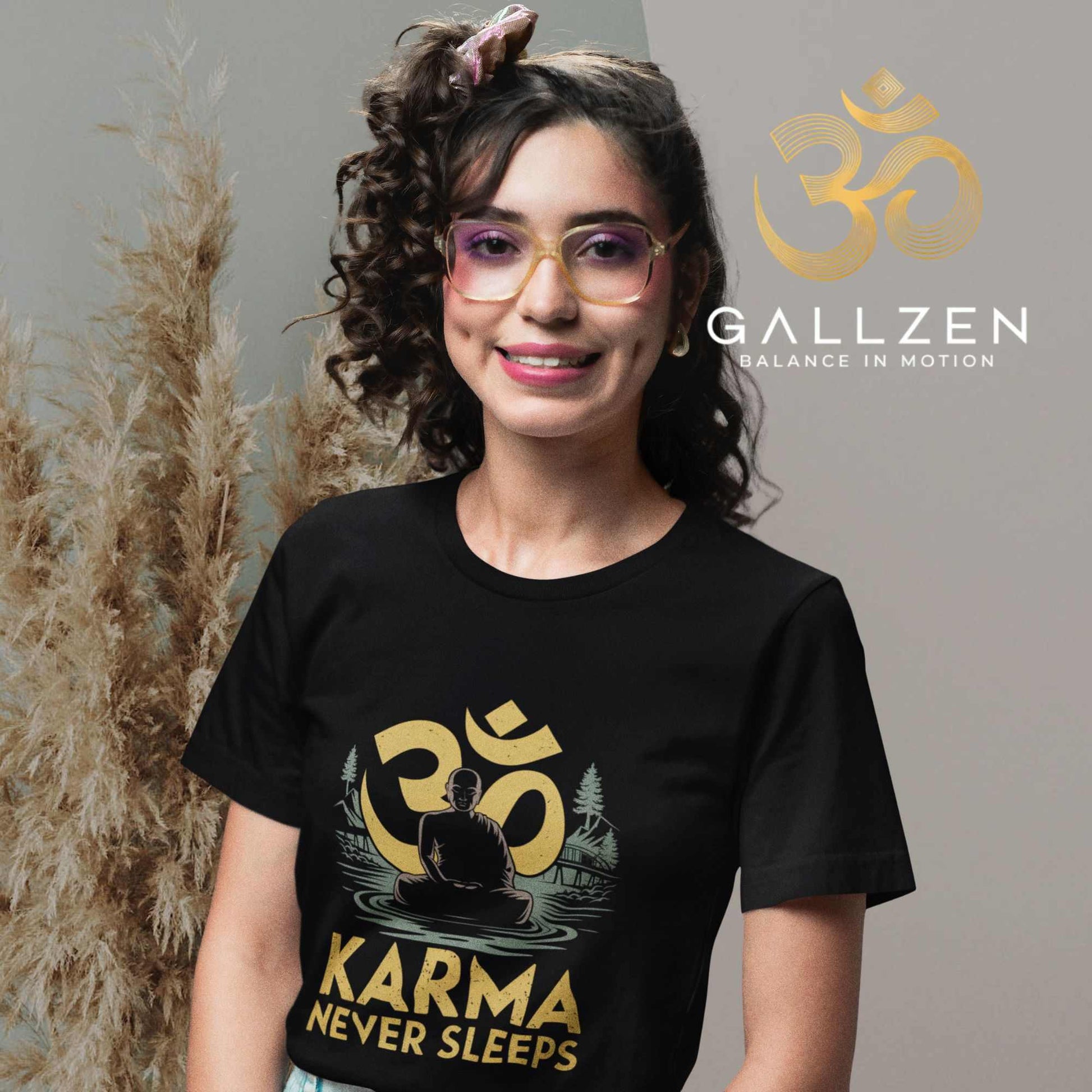 Smiling woman wearing a black spiritual t-shirt featuring a meditating figure, gold Om symbol, and nature scene