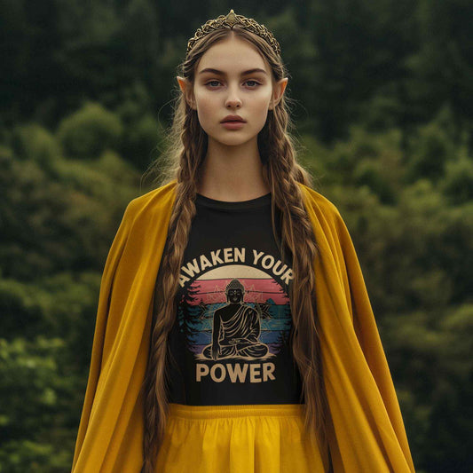 Person wearing a black t-shirt with 'Awaken Your Power' and a yellow cloak in a forest setting