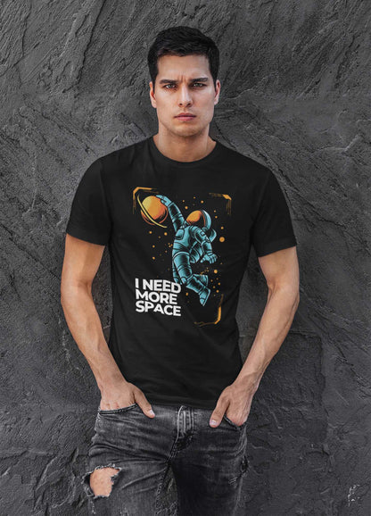 man-standing-against-a-dark-wall-wearing-a-black-tee-with-a-printed-blue-astronaut-design