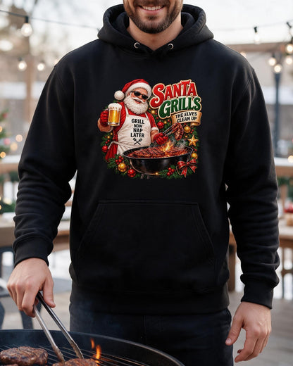 Man wearing a black Santa grilling Christmas hoodie, using tongs to cook meat on a barbecue with the chest print visible