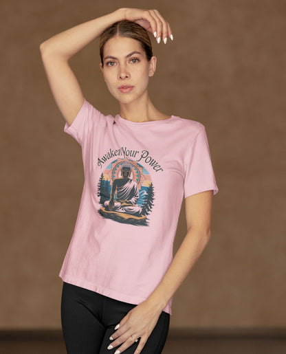 A woman models a pink spiritual strength tee, emblazoned with a meditating Buddha design and the empowering phrase "Awaken Your Power," symbolizing mindfulness and inner peace.