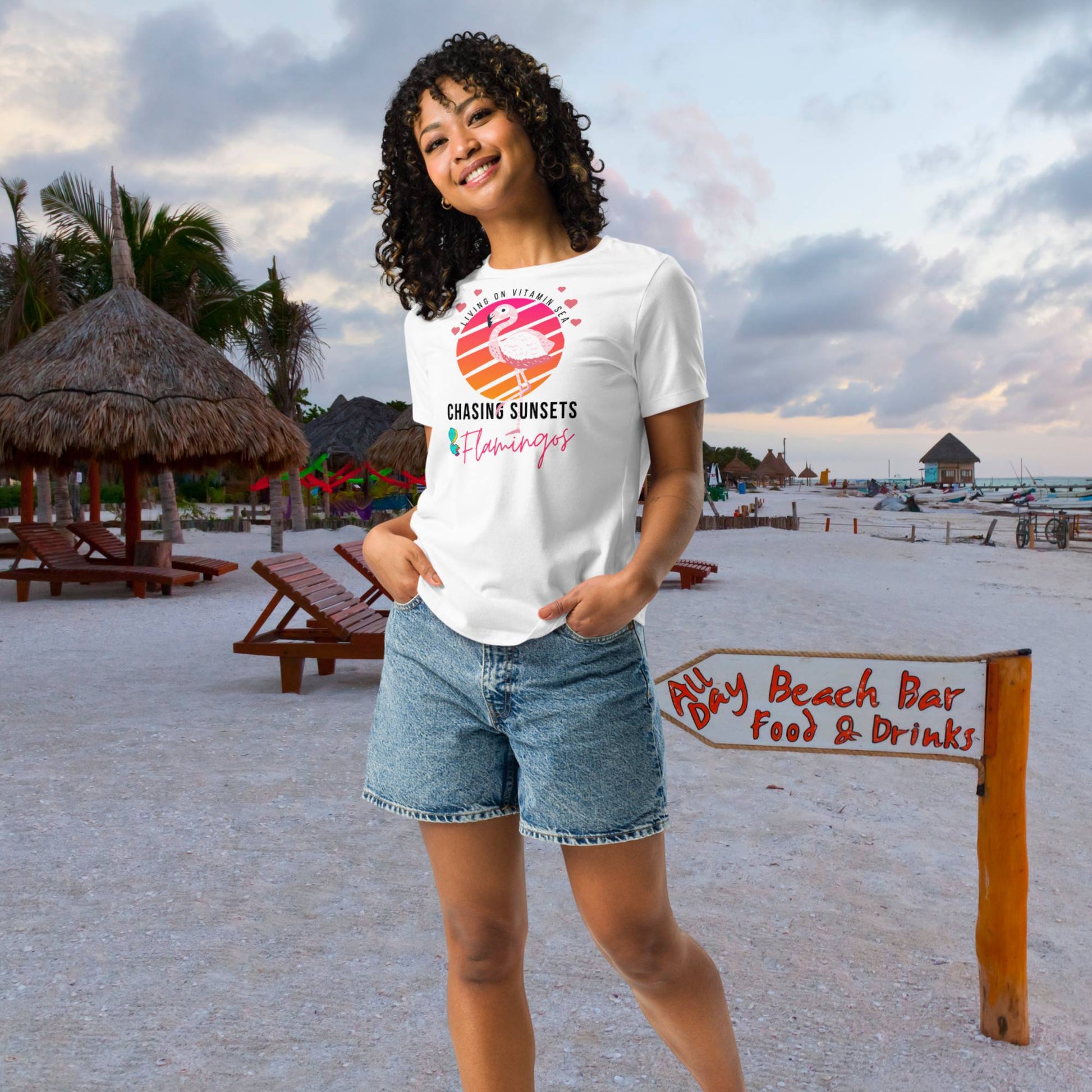 woman-walking-on-the-beach-in-the-evening-at-sunset-wearing-a-white-t-shirt-with-vitamin-sea-design